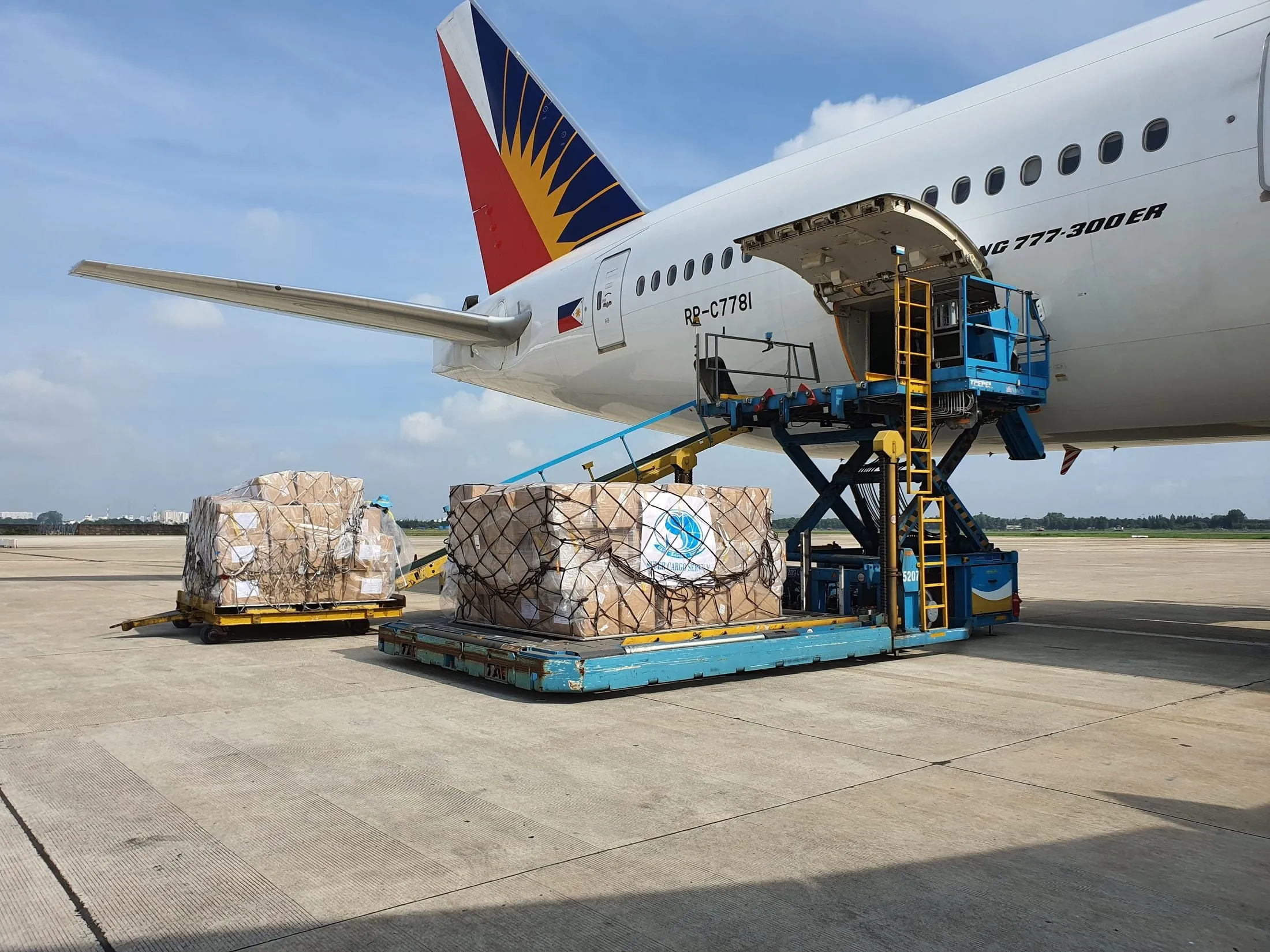 Palletised cargo being loaded into a widebody aircraft on the apron